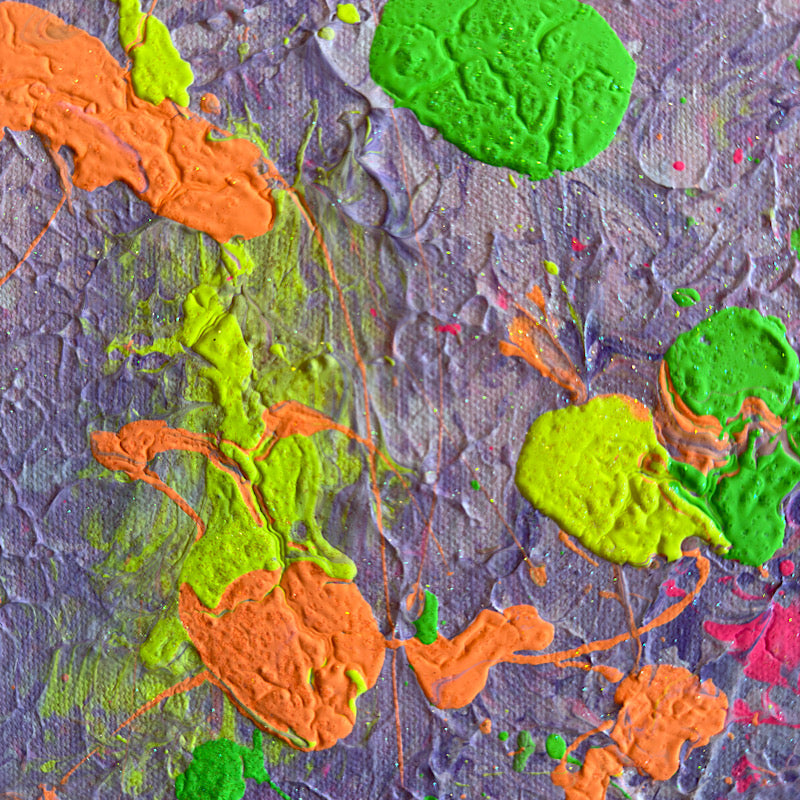 Timothy laughing at the beach holding Little Ocean 05 with ocean waves behind him, full canvas showing lavender base with neon green, pink and orange splashes