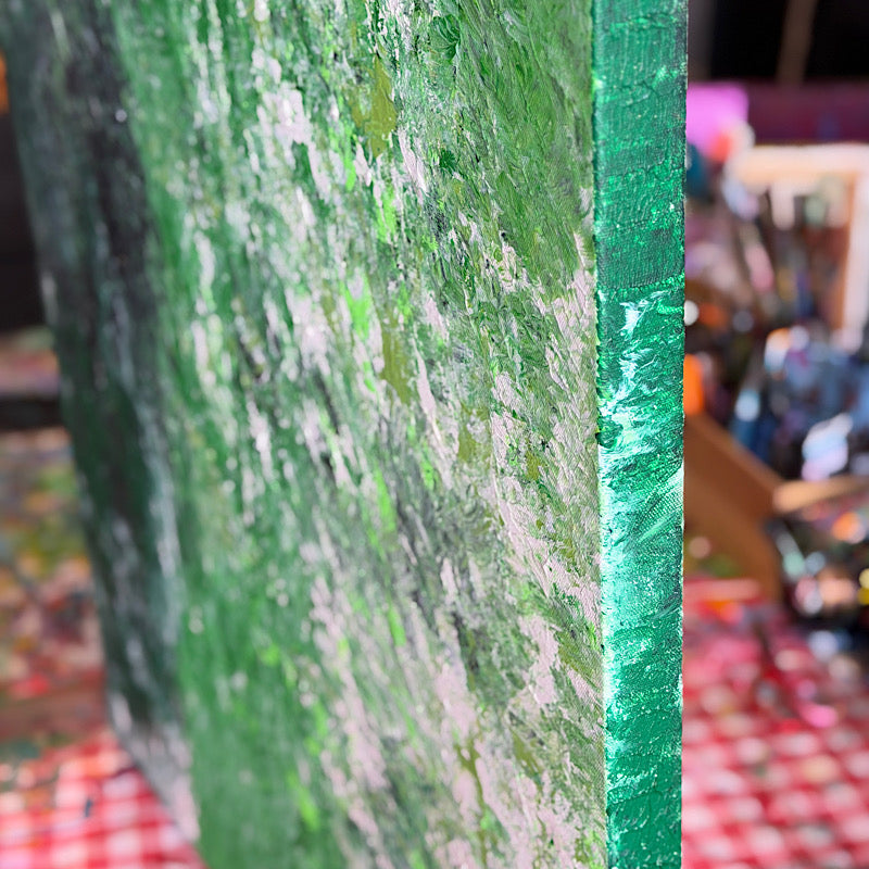 Atlantic, Original by Clara Woods — Clara holding the large green painting on the beach, smiling, ocean waves and grey sky in the background