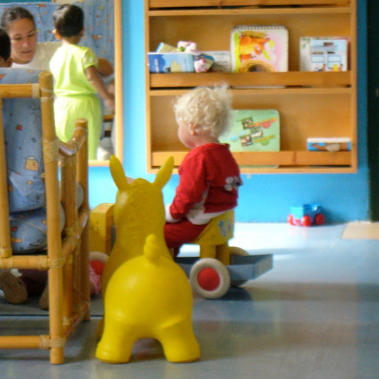 Children playing in a classroom with educational materials and toys.